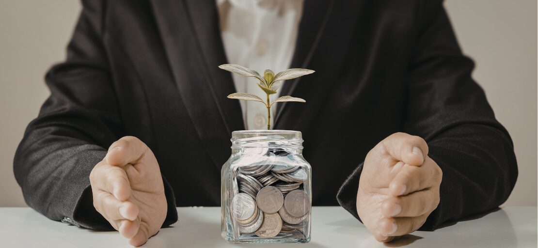 A professional financial advisor sitting across a table from a client couple in a warm, collaborative meeting room, focusing on a financial plan rather than investment charts to represent stewardship.
